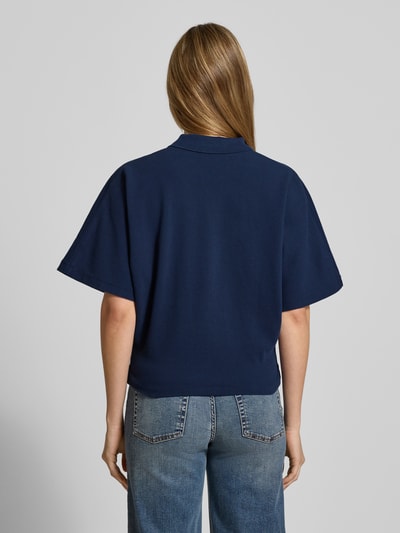 Modelka kobieca nosi granatowe Boxy Fit Poloshirt mit Label-Stitching od Polo Ralph Lauren z krótkimi rękawami z czystej bawełny, widok całej sylwetki od tyłu.