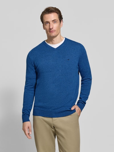 Männermodel trägt Regular Fit Strickpullover aus Baumwoll-Mix mit Kaschmir-Anteil von Fynch-Hatton in Blau, V-Ausschnitt, Ganzkörperansicht von vorne. Rückenlänge bei Größe M 67 cm, Ärmellänge 68 cm, elastische Abschlüsse, glatte Oberfläche.