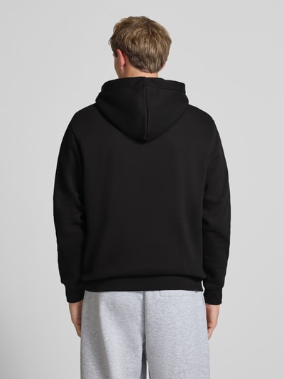Männermodel trägt Regular Fit Hoodie aus reiner Baumwolle mit Label-Detail von Alpha Industries, Schwarz, Rückenansicht, Ganzkörperansicht Rückansicht
