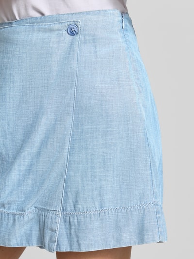 Frauenmodel trägt Skort aus Lyocell-Baumwoll-Mix in Wickel-Optik von JAKE*S STUDIO WOMAN, hellblauer Denim-Look, Nahaufnahme Hüfte