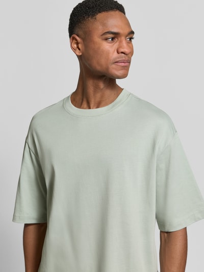 Männermodel trägt Relaxed Fit T-Shirt aus reiner Baumwolle Modell 'RELEXASPEN' von SELECTED HOMME in Unifarbe, Nahaufnahme Oberkörper.