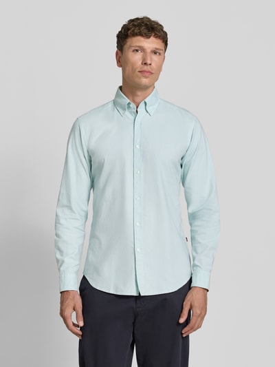 Männermodel trägt Regular Fit Freizeithemd aus reiner Baumwolle Modell 'RICKERT' von BOSS Orange in Hellblau, Ganzkörperansicht von vorne.