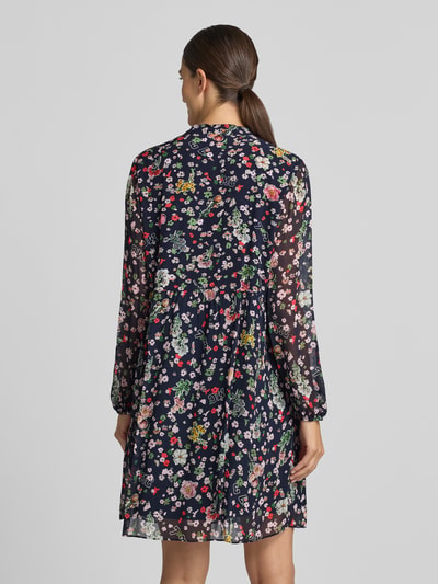 Männermodel trägt Relaxed Fit Kleid aus reiner wiskoza von Marc Cain, ozdobna kokarda, półprzezroczysty materiał, z długim rękawem, kwiatowy nadruk na całej powierzchni, długość tyłu w rozmiarze 36: 80 cm, szerokość w rozmiarze 36: 38 cm, długość rękawów w rozmiarze 36: 64 cm, widok całej sylwetki od tyłu
