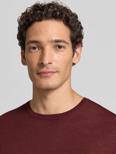Männermodel trägt Strickpullover aus Schurwolle mit Rundhalsausschnitt von MAERZ Muenchen in Bordeaux, Nahaufnahme Oberkörper, Regular Fit
