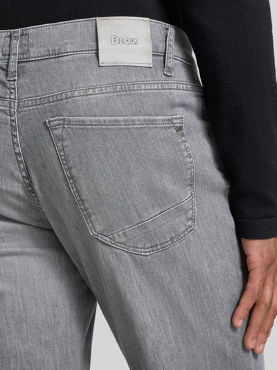 Männermodel trägt Jeans mit Eingrifftaschen Modell 'Chuck' von BRAX aus grauem Baumwoll-Elasthan-Mix, Slim-Fit, Detailaufnahme Rückansicht.