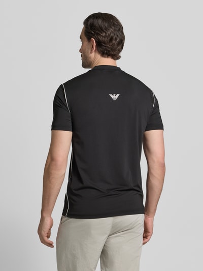 Männermodel trägt Regular Fit T-Shirt mit Stehkragen von EA7 Emporio Armani in Schwarz mit Label-Print, Ganzkörperansicht Rückansicht.