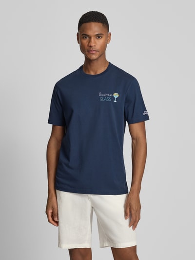 Męski model nosi t-shirt z haftami model 'PORTOFINO' od MC2 Saint Barth, bawełna, krój regular fit, okrągły dekolt, długość tyłu w rozmiarze M: 68 cm, widok całej sylwetki z przodu.