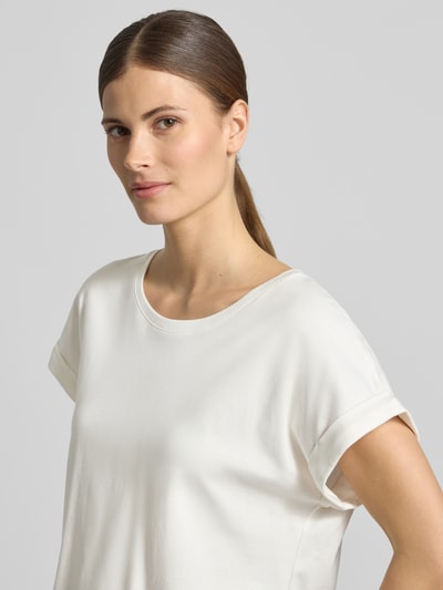 Frauenmodel trägt T-Shirt mit fixiertem Ärmelaufschlag von monari aus Reine Baumwolle mit Rundhalsausschnitt, Label-Detail, Nahaufnahme Oberkörper.