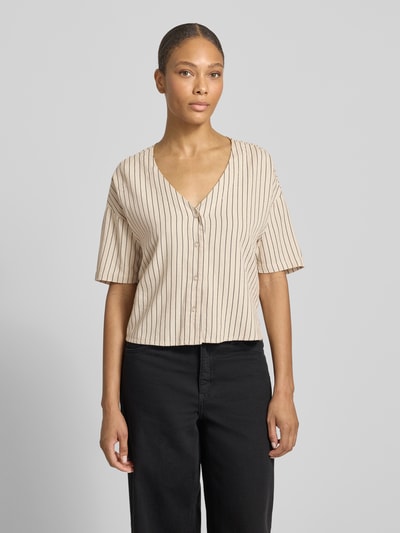 Modelka kobieca nosi Boxy Fit Hemdbluse aus Viskose-Leinen-Mix Modell 'MYMILO' od Vero Moda, jasnobeżowy z czarnymi paskami, flammgarn, dekolt V, tunikowy kołnierz, rękaw 3/4, przód na guziki, widok całej sylwetki z przodu.