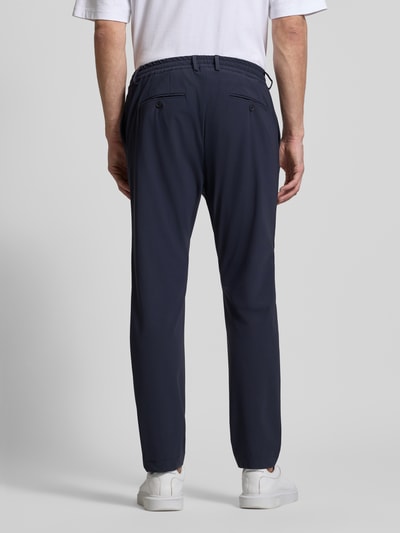 Männermodel trägt Slim Fit Hose mit Paspeltaschen am Gesäß von CRUNA in Dunkelblau, Material-Mix mit Stretch-Anteil, Ganzkörperansicht Rückansicht.
