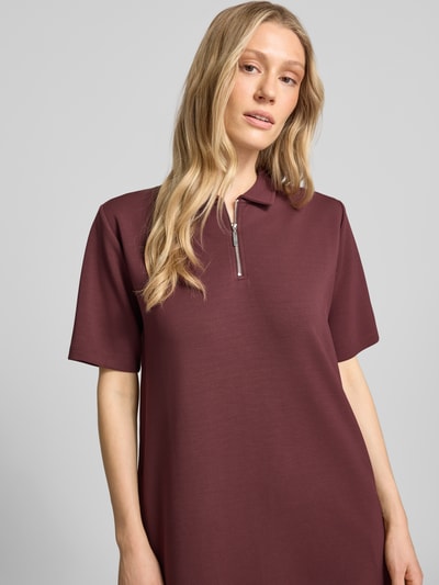 Frauenmodel trägt Polokleid mit kurzem Reißverschluss von Christian Berg Woman in dunklem Rot, aus Material-Mix mit Modal-Anteil, Gerader-Schnitt, Polokragen, Midikleid, Nahaufnahme Oberkörper.