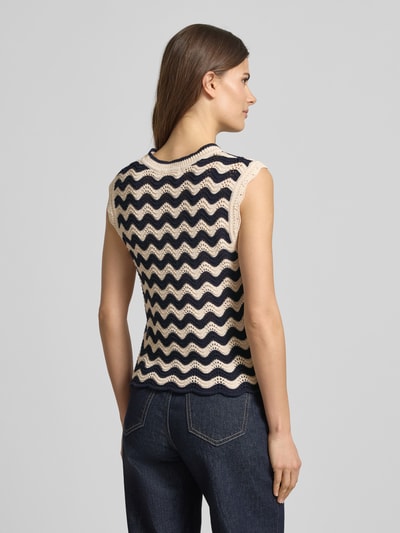 Frauenmodel trägt Pullunder im Allover-Look mit Wellensaum von Christian Berg Woman, Regular-Fit, creme und dunkelblau, Rückenansicht. Rückenlänge bei Größe S: 55 cm, Rundhalsausschnitt, strukturierte Stricktextur. Ganzkörperansicht Rückansicht.