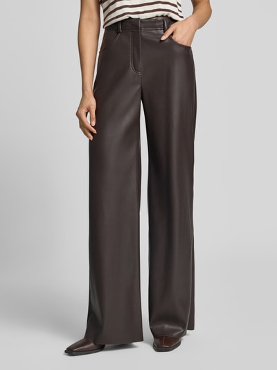 Frauenmodel trägt Straight Fit Hose mit Eingrifftaschen von Marc Cain in Leder-Optik, dunkles Braun, glatte Textur, Nahaufnahme Oberkörper.