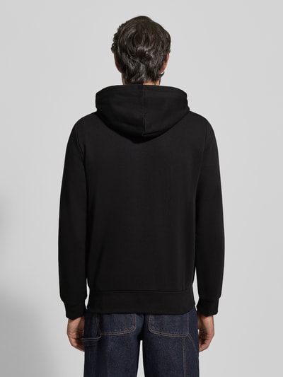 Männermodel trägt Sweatjacke mit Reißverschluss von LACOSTE in Schwarz aus Baumwoll-Mix, Regular-Fit, gerippte Abschlüsse, Rückenansicht.