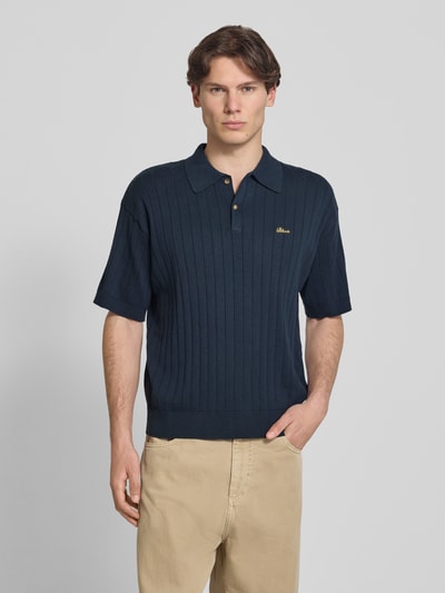 Männermodel trägt Regular Fit Strick-Poloshirt mit Label-Stitching von BLKVIS in Dunkelblau, reine Baumwolle, Ripp-Optik, Knopfleiste, Rückenlänge 68 cm bei Größe M, Ganzkörperansicht von vorne.