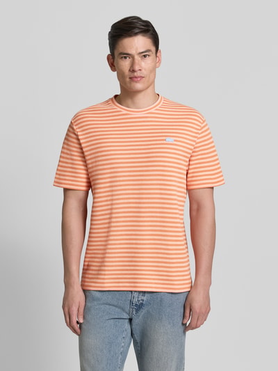 Männermodel trägt Regular Fit T-Shirt aus Baumwoll-Mix von Lacoste, Mehrfarbig, Gestreift, Logo-Applikation, Ganzkörperansicht von vorne.
