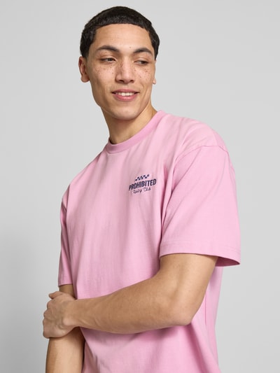 Männermodel trägt Regular Fit T-Shirt aus reiner Baumwolle Modell 'IN A RUSH' von PROHIBITED in Rosa, Nahaufnahme Oberkörper. Rückenlänge Größe M: 67 cm, Stehkragen, Label-Stitching.