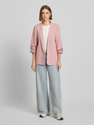 Frauenmodel trägt Blazer mit Schalkragen von PIECES in Unifarbenes-Design mit gelegte Falten, lockere Passform, Ganzkörperansicht von vorne.