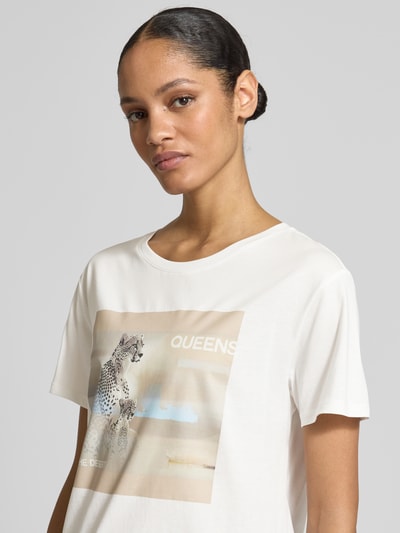 Frauenmodel trägt Regular Fit T-Shirt mit Strasssteinbesatz von monari aus Reine Baumwolle mit Motiv-Print, kurzärmelig, Rundhalsausschnitt, Rückenlänge bei Größe 36: 55 cm, Nahaufnahme Oberkörper.