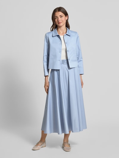 Frauenmodel trägt Glockenrock mit Gürtel und rückseitigem Reißverschluss von Windsor aus hellblauem Baumwoll-Mix, A-Linie, Midi, Ganzkörperansicht von vorne