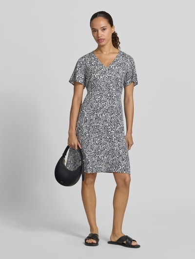 Kobiece modelka nosi Minikleid aus Viskose mit V-Ausschnitt und Knopfleiste von Zero, wzór na całej powierzchni, linia a, dekolt w serek, listwa guzikowa, długość tyłu w rozmiarze 36: 76 cm, szerokość w rozmiarze 36: 45 cm, długość rękawów w rozmiarze 36: 21 cm, jasne i ciemne kolory, tekstura miękkiej tkaniny, widok całej sylwetki z przodu.