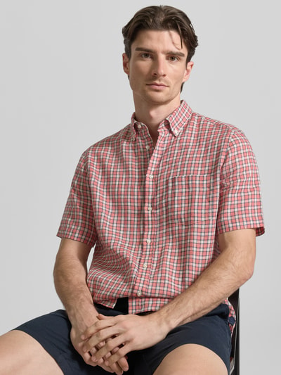 Männermodel trägt Regular Fit Freizeithemd aus Leinen von Christian Berg Men, kariert in Rot und Weiß, mit Brusttasche, Nahaufnahme Oberkörper.