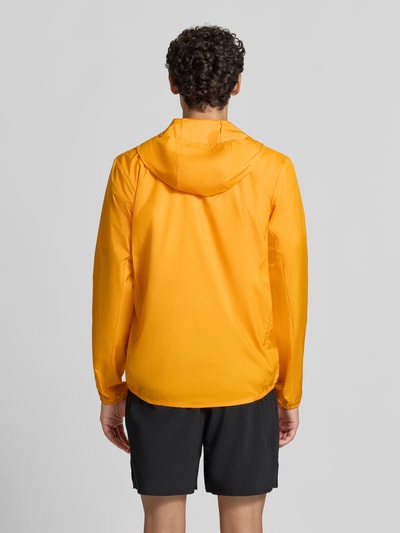 Männermodel trägt leuchtend gelbe Regular Fit Trainingsjacke mit Logo-Print Modell 'Core' von ASICS TIGER, Rückenansicht, Kontext: Herren Trainingsjacke mit Kapuze, Stehkragen, Reißverschluss und elastischen Abschlüssen
