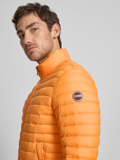 Männermodel trägt Steppjacke mit Zweiwege-Reißverschluss von Colmar Originals in Orange, Regular-Fit, Stehkragen, Eingrifftaschen, Nahaufnahme Oberkörper. Rückenlänge 65 cm, Schulterbreite 47 cm, Brustweite 43 cm, Ärmellänge 67 cm bei Größe 50.