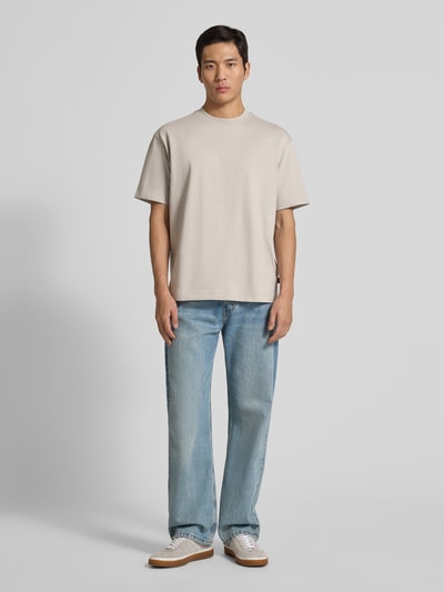 Männermodel trägt Regular Fit T-Shirt aus Baumwoll-Mix Modell 'TEETIM' von BOSS Orange, Optik: Unifarben, Label-Print, Rundhals, Ganzkörperansicht von vorne.