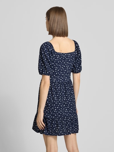 Frauenmodel trägt Minikleid mit Puffärmeln Modell 'HILLARY' von Only, Optik:Allover-Muster, Tailliert, Mini, Karree-Ausschnitt, Florales-Muster, Schleife, Crêpe, Ganzkörperansicht Rückansicht.