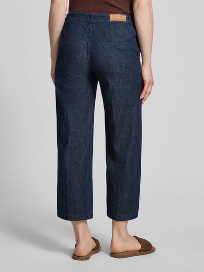 Frauenmodel trägt Jeans mit Bügelfalten und Eingrifftaschen von Comma aus reiner Baumwolle, Wide Leg, dunkelblau, Ganzkörperansicht Rückansicht.