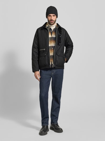 Männermodel trägt Regular Fit Parka aus reiner Baumwolle von Barbour in Unifarben mit Cord-Besatz, Zweiwege-Reißverschluss, Ganzkörperansicht von vorne.