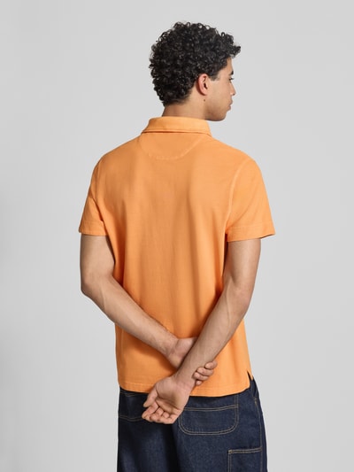 Männermodel trägt Regular Fit Poloshirt aus reiner Baumwolle von Replay in Orange mit Polokragen und Label-Stitching, Rückenlänge 73 cm, Ganzkörperansicht Rückansicht.