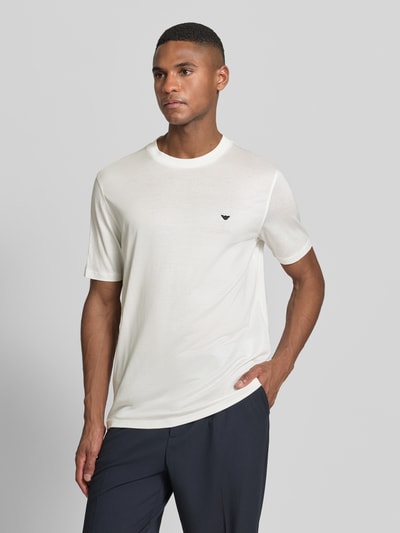 Männermodel trägt T-Shirt mit Label-Stitching von Emporio Armani, Lyocell-Baumwoll-Mix, Regular Fit, gerippter Rundhalsausschnitt, Ganzkörperansicht von vorne.