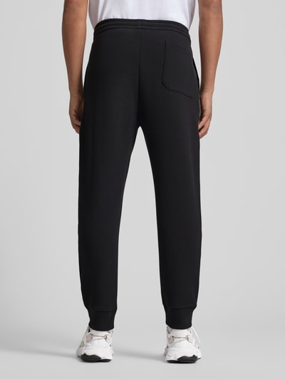Männermodel trägt Regular Fit Sweatpants aus Baumwoll-Mix Modell 'JOIN HADIKO' von BOSS Green, Optik: Unifarben, Piqué, Ganzkörperansicht Rückansicht.