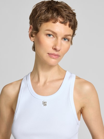 Frauenmodel trägt Slim Fit Top mit Logo-Applikation von Liu Jo White aus elastischem Baumwoll-Mix in Weiß, Nahaufnahme Oberkörper.