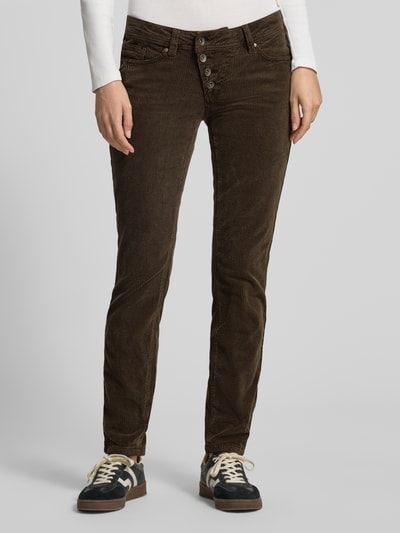 Kobiece model prezentuje spodnie sztruksowe Slim Fit Cordhose aus Baumwoll-Mix von Buena Vista w ciemnobrązowym kolorze, wyraźna faktura sztruksu, całkowity widok z przodu.