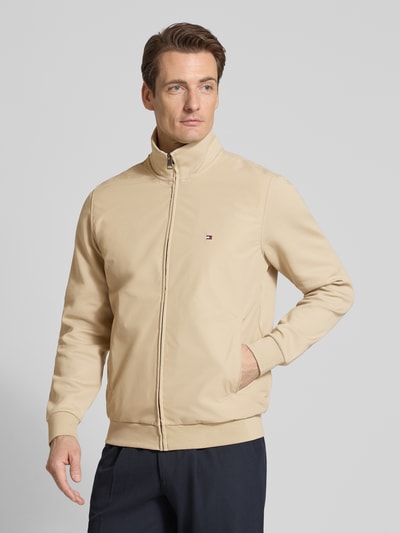 Männermodel trägt Regular Fit Blouson aus Baumwoll-Mix von Tommy Hilfiger, beige, unifarben, Logo-Stitching, Ganzkörperansicht von vorne.