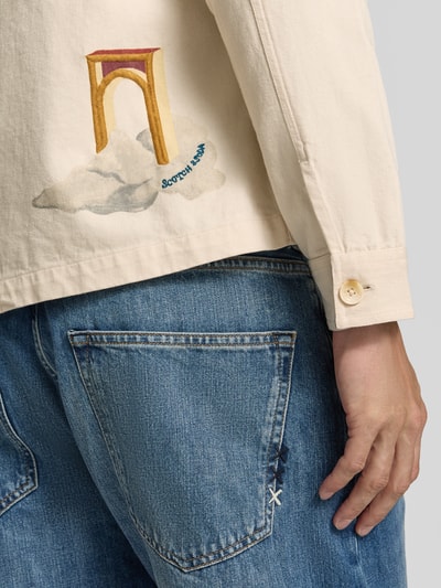 Männermodel trägt Regular Fit Overshirt mit Motiv-Prints- und -Applikationen von Scotch & Soda aus Baumwolle, Nahaufnahme Oberkörper, Rückenansicht.