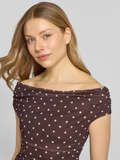Vrouwenmodel draagt Top aus Mesh im Off-Shoulder-Design Modell 'Mimi' van Forever New, bruin met witte stippen, aansluitende fit, mesh textuur, close-up bovenlichaam.