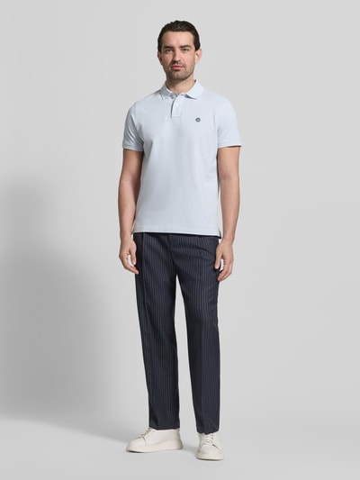Männermodel trägt Slim Fit Poloshirt mit Logo-Stitching von MCNEAL in Hellblau, reine Baumwolle, Polokragen, Ganzkörperansicht von vorne.