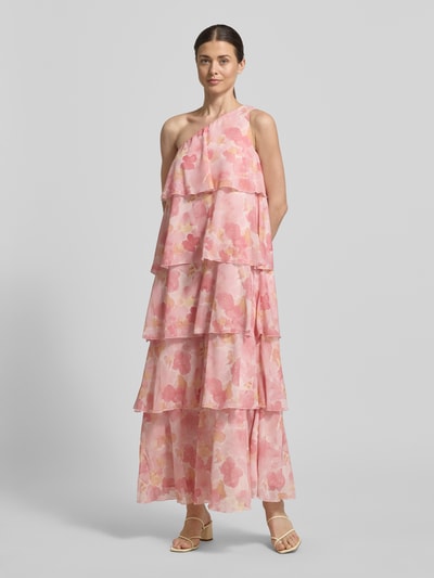 Vrouwenmodel draagt maxi-jurk Ausgestelltes Maxikleid mit Rüschendetail Modell 'FELICIA' van Vero Moda, all-over bloemenmotief, uitlopend, maxilengte, asymmetrische hals en rugdecolleté, ruchedetail, one-shoulder model, mouwloos, volantzoom, met onderjurk, materiaalverwerking: chiffon, pastelroze tinten, gelaagde stof, lichte textuur. Ganzlichaanszicht van voren.