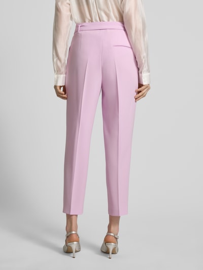 Frauenmodel trägt Regular Fit Schmale Hose mit Gürtel Modell 'TAPIAH' von BOSS in Rosa, Optik: Unifarben, High-Waist, Bundfalte, Bügelfalten, Gürtelschlaufen, Gürtel, Knopf und verdeckter Reißverschluss, Eingrifftaschen, angedeutete Gesäßtasche, Ganzkörperansicht Rückansicht.