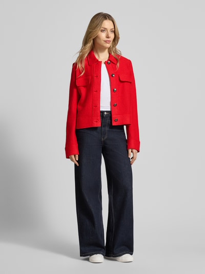 Vrouwenmodel draagt Regular Fit Jacke aus Viskose-Mix mit Woll-Anteil van Betty Barclay in felrood, borstzakken, knoopsluiting, witte top, donkerblauwe wijde broek, witte sneakers, volledige lichaamsweergave van voren, Viskose-mix met wol, ruglengte maat 36: 53 cm, borstwijdte maat 36: 51 cm, mouwlengte maat 36: 62 cm.