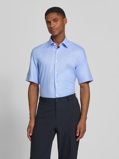 Männermodel trägt Regular Fit Businesshemd aus reiner Baumwolle Modell 'H-JOE-K-SH-C1-262' von BOSS in Hellblau mit Kentkragen, Allover-Muster und durchgehender Knopfleiste, Ganzkörperansicht von vorne.