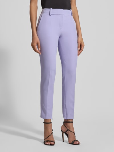 Frauenmodel trägt Slim Fit Schmale Hose mit Label-Applikation Modell 'HEDIMA-1' von HUGO, unifarben, mit Reißverschlüssen, Ganzkörperansicht von vorne.