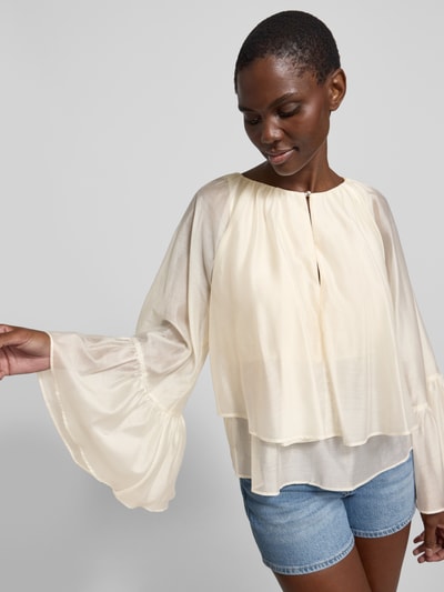 Frauenmodel trägt Relaxed Fit Bluse aus Lyocell-Mix mit Rüschenbesatz von Liu Jo White in Creme mit Rundhalsausschnitt und Schlüssellochausschnitt, lockere Passform, langärmlig, feine transparente Textur, Damen Bluse mit Raffung, Ganzkörperansicht von vorne.