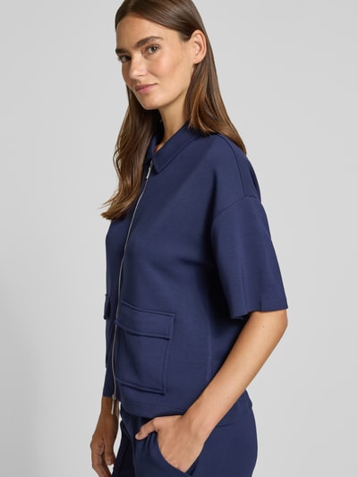 Frauenmodel trägt Jacke mit Umlegekragen von Christian Berg Woman, elastyczna mieszanka materiałów, prosty krój, wykładany kołnierz, zamek błyskawiczny, rękaw o dł. 1/2, nakładane kieszenie, kolor granatowy, Ganzkörperansicht von vorne.