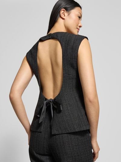 Kobiece modelka nosi Blusentop in Bouclé-Optik Modell 'Rafli' od Neo Noir, czarny materiał, wiązanie z tyłu, tekstura bouclé, dopasowany krój, widok całej sylwetki z tyłu.