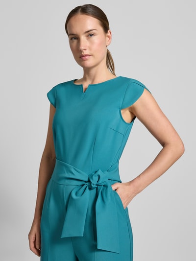 Vrouwenmodel draagt Regular Fit jumpsuit met strikceintuur van Betty Barclay in helder turquoise, gladde stof, Nahaufnahme Oberkörper. Dames jumpsuit.